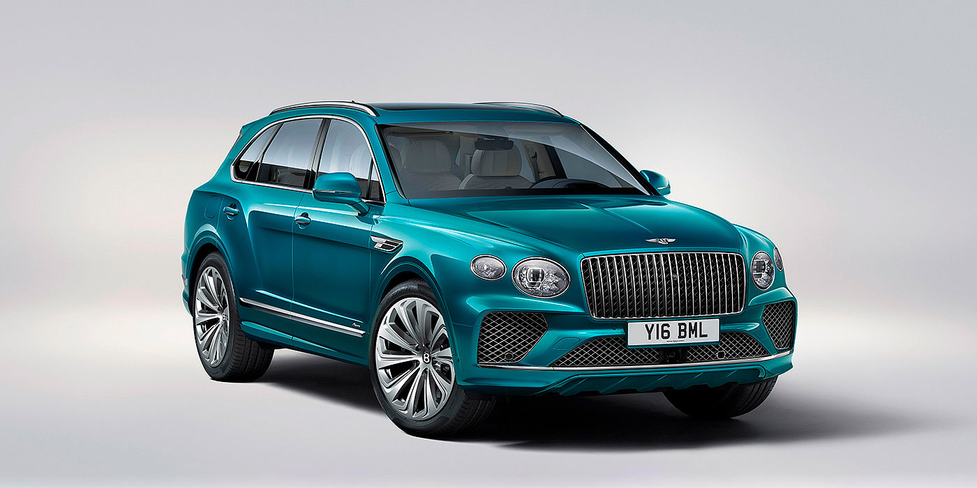 Bentley Basel Bentley Bentayga Azure front three-quarter view, featuring a fluted chrome grille with a matrix lower grille and chrome accents in Topaz blue paint.