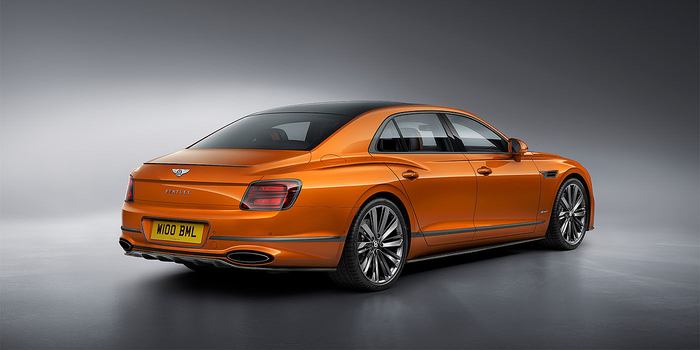 Bentley Basel Bentley Flying Spur Speed in Orange Flame colour rear view, featuring Bentley insignia and enhanced exhaust muffler.