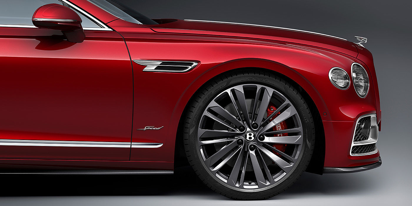 Bentley Basel Bentley Flying Spur Speed sedan front wheel in close up with Dragon Red II paint