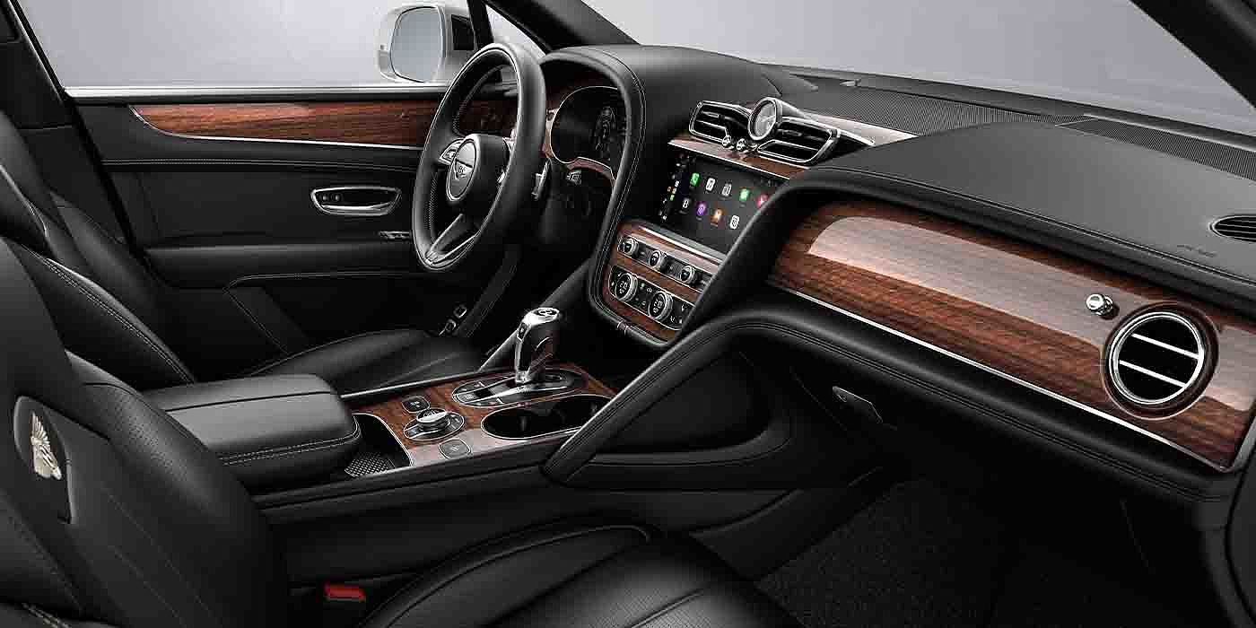 Bentley Basel Bentley Bentayga EWB interior with a Crown Cut Walnut veneer, view from the passenger seat over looking the driver's seat.