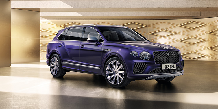 Bentley Basel Bentley Bentayga Extended Wheelbase Mulliner SUV front three quarter in Tanzanite Purple paint with a gold patterned background