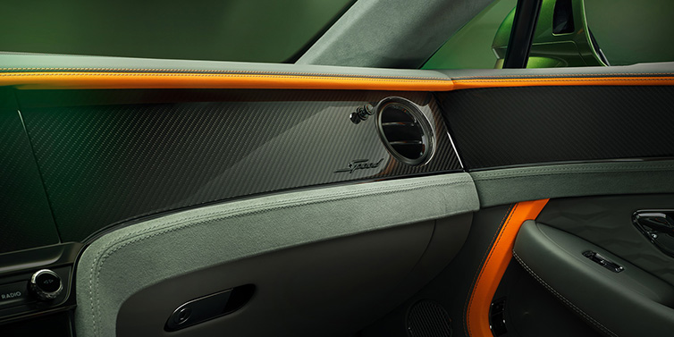 Bentley Basel Bentley Continental GT Speed coupe front interior dash detail with high gloss carbon fibre veneer surrounded by Mandarin by Mulliner and Gravity Grey hides