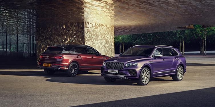 Bentley Basel A duo of Bentley Bentayga Extended Wheelbase Mulliner SUVs parked in a city environment, with Tanzanite Purple and Cricket Ball red exterior paint