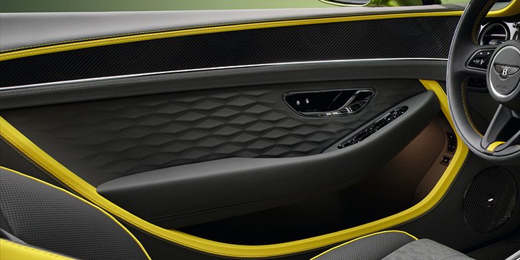 Bentley Basel Bentley Continental GTC Speed convertible interior door details featuring Gravity Grey and Cyber Yellow by Mulliner hides and high gloss carbon fibre veneer