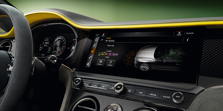 Bentley Basel Bentley Continental GTC Speed convertible front interior centre console with MMI screen showing Air Quality visualisation surrounded by Cyber Yellow by Mulliner and Gravity Grey hides and high gloss carbon fibre veneer