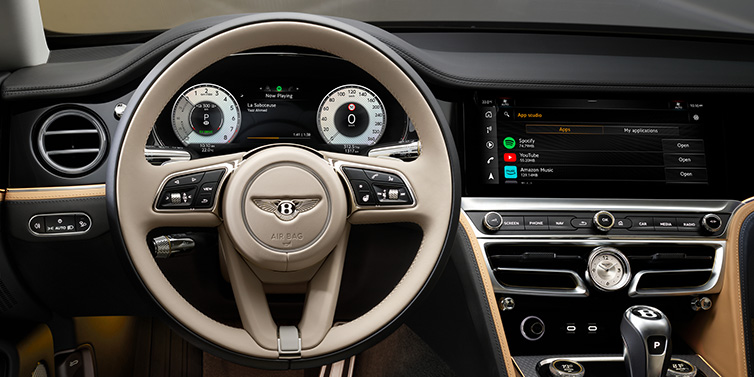 Bentley Basel Bentley Flying Spur Mulliner sedan front interior detail of steering wheel and driver screens surrounded by Linen and Beluga black hides